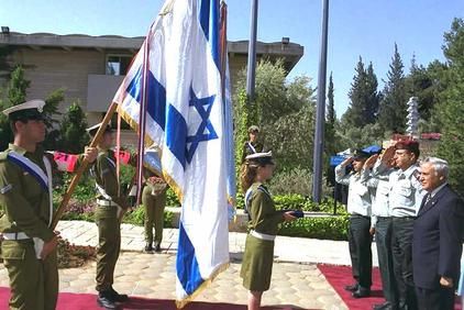 president moshe katsav attaching the ribbon onto the national flag